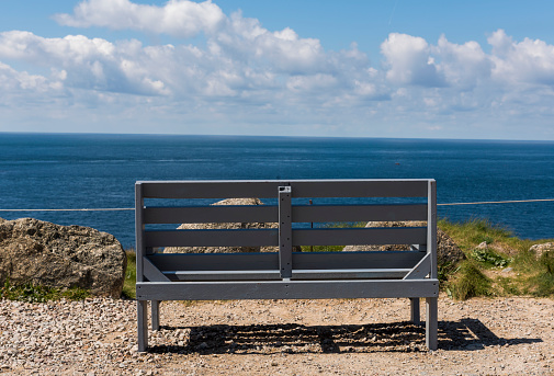 Last/first bench at  Lands' End in summer with blue sky and ocean.