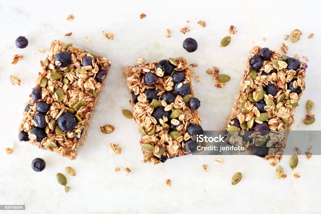 Superfood breakfast bars, above view on marble background Superfood breakfast bars with oats and blueberries, above view on white marble background Protein Bar Stock Photo