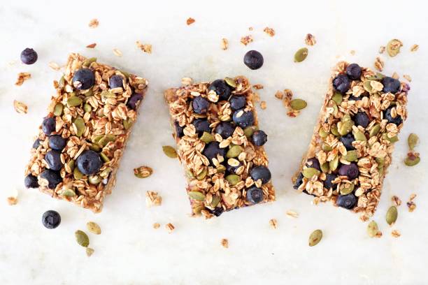 Superfood breakfast bars, above view on marble background Superfood breakfast bars with oats and blueberries, above view on white marble background oats food stock pictures, royalty-free photos & images