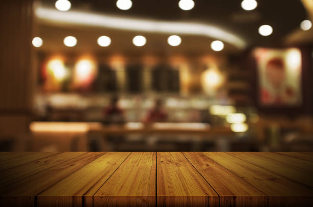 istock Empty wooden table top with blurred restaurant or cafe light background. can be used product display. 831717668