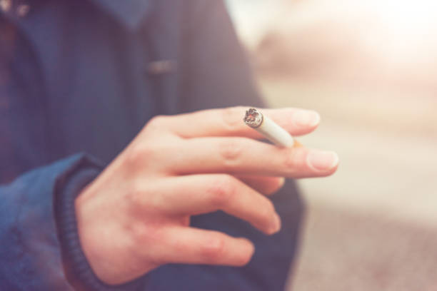 immagine tonica di una donna che fuma una sigaretta - smoking women smoke smoking issues foto e immagini stock