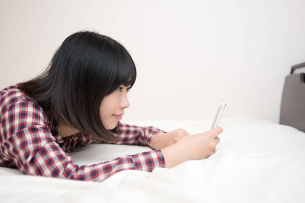 istock young woman with cell phone before sleeping 831732586