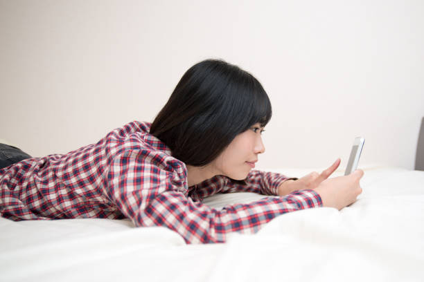 istock young woman with cell phone before sleeping 831732618