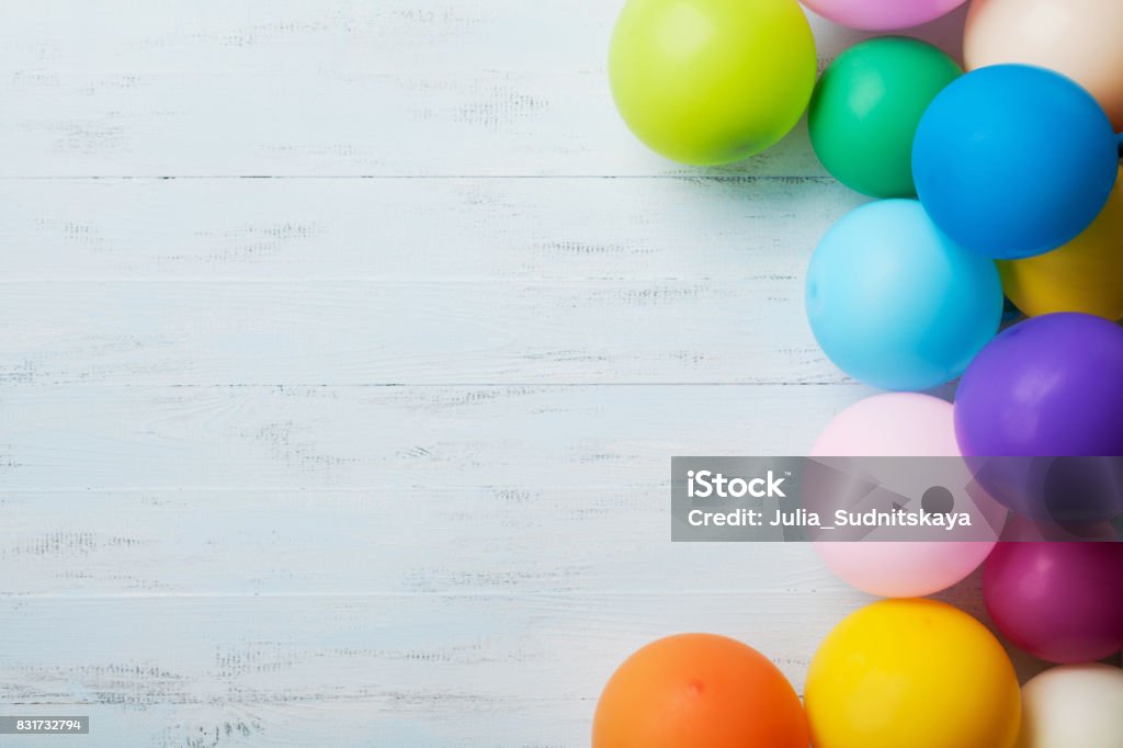 Festliche Grußkarte. Haufen von bunten Luftballons zu blauen hölzernen Tischplatte sehen. Geburtstag oder Party Hintergrund. Flache Laien Stil. - Lizenzfrei Party Stock-Foto