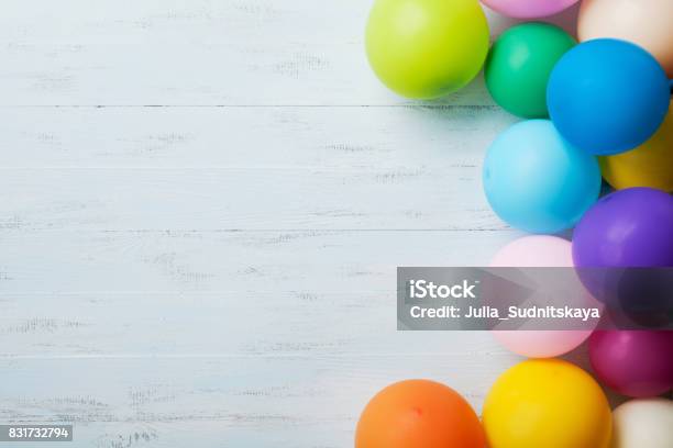 Festive Greeting Card Heap Of Colorful Balloons On Blue Wooden Table Top View Birthday Or Party Background Flat Lay Style Stock Photo - Download Image Now