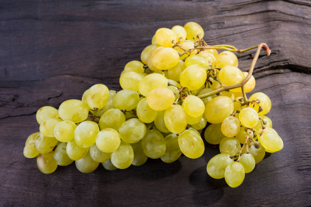 istock Yellow fruit grapes is sitting on the dark wood 831733804