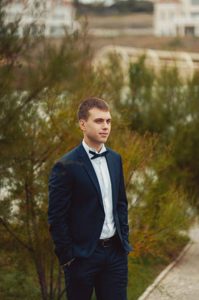 istock Groom in a suit and a bow tie for a walk 831736290