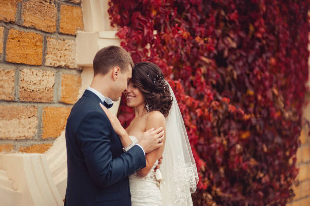 istock Wedding couple on a walk near a wall with red leaves 831736374