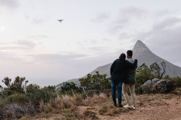 istock Young couple flying drone in countryside 831740066
