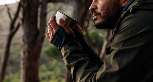 istock Close up of male hiker drinking coffee 831740492