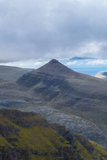istock Single mountain top against Atlantic sea backdrop and cloudy sky 831740746