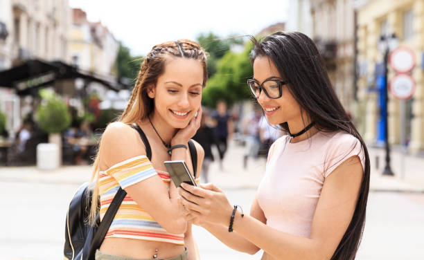 istock Girls hanging out and using smart phone on street 831741322