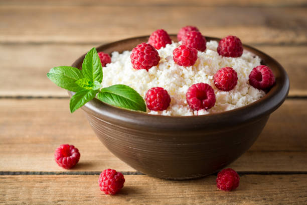 istock Cottage cheese with raspberry and mint in ceramic bowl on rustic wooden table 831744312