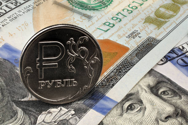 One ruble coin on dollar banknote. Closeup, macro shot stock photo
