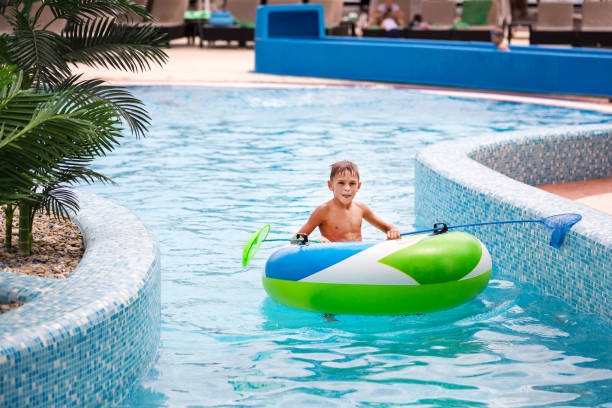 istock Little boy sitting in inflatable boat and having fun with nettles 831744782