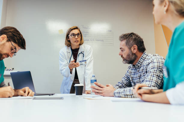 istock Female doctor briefing her colleagues in boardroom 831745288