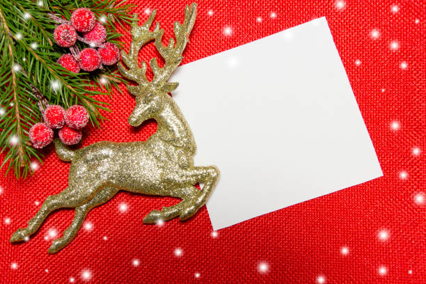 christmas backgrond.gold deer,fir branches ,red berries and empty white card on background of red cloth. - reindeer christmas decoration gold photography imagens e fotografias de stock