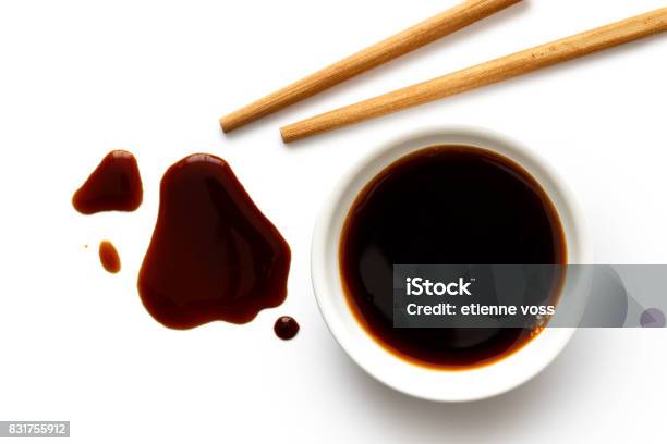 Soya Sauce In White Ceramic Bowl On White From Above With Wooden Chopsticks Spilled Soya Sauce Stock Photo - Download Image Now