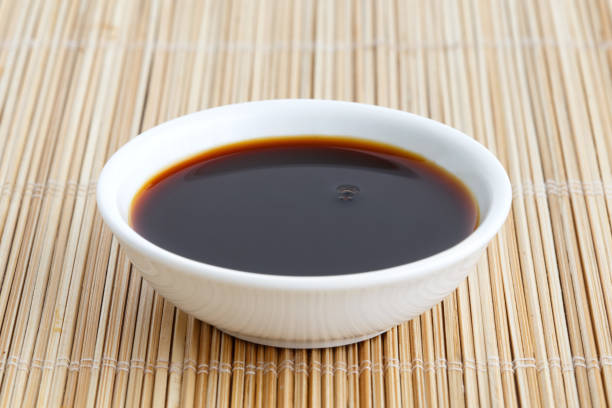 istock Soya sauce in white ceramic bowl isolated on bamboo mat. 831763450
