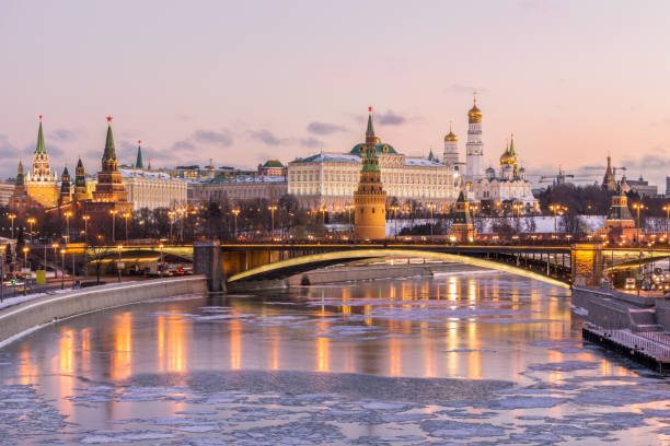 illuminated moscow kremlin and moscow river in winter morning. pinkish and golden sky with clouds. russia - kremlin imagens e fotografias de stock