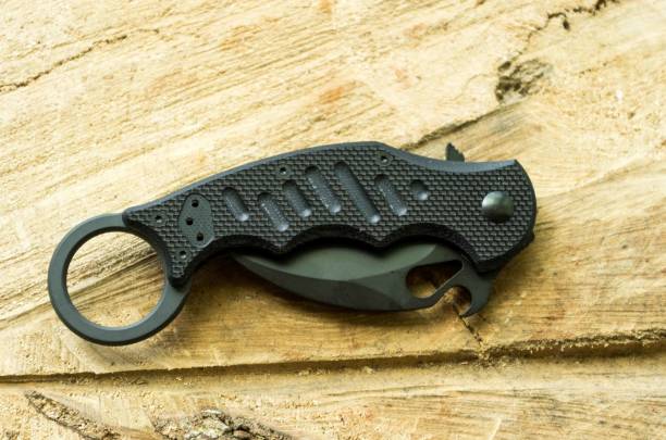 istock Tactical knife in a folded position on a wood background. 831783368