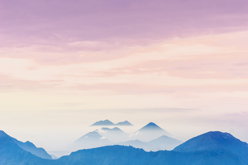 View of violet sunset over foggy volcanoes of Lago Atilan