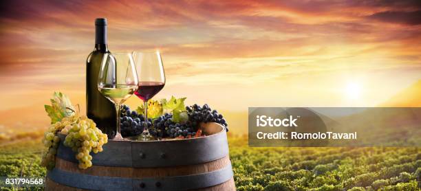 Bottle And Wineglasses On Barrel In Vineyard At Sunset Stock Photo - Download Image Now