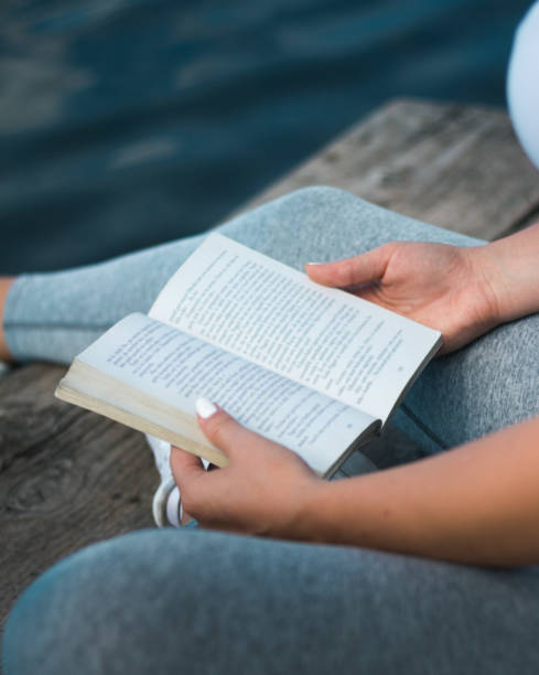 istock Woman relaxes on lake, reads a book 831798654