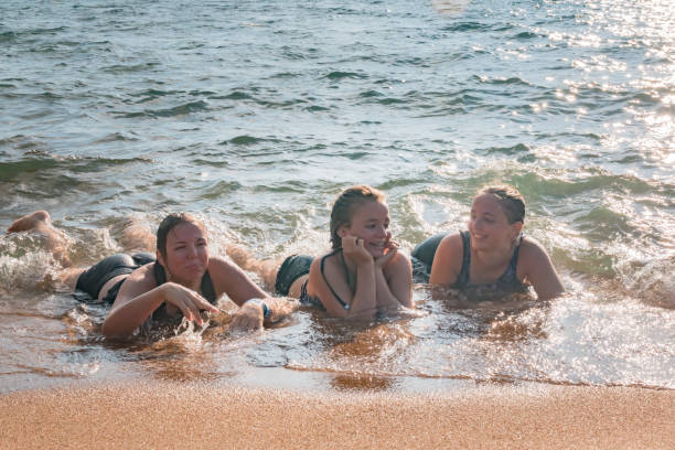 istock Waves Splash Girls Laying on the Sand 831801834