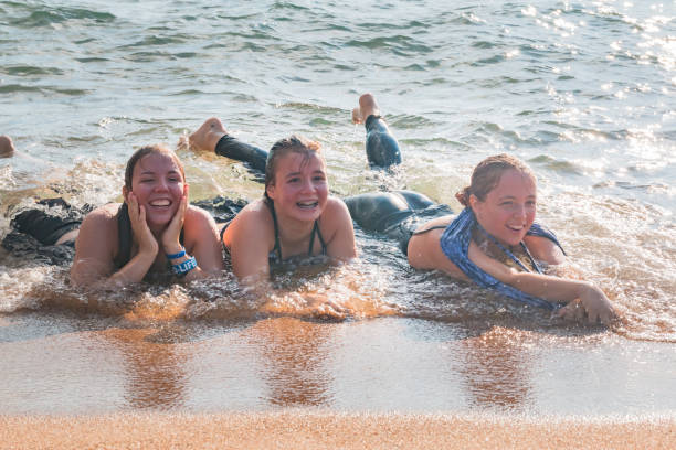 istock Waves Splash Girls Laying on the Sand 831801886