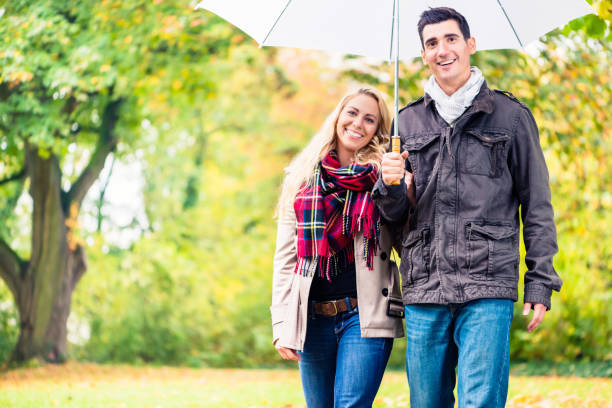 istock Couple enjoying fall day having walk despite the rain 831808898