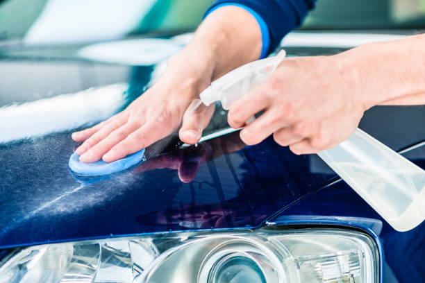 istock Happy man looking at camera while waxing a blue car 831811764