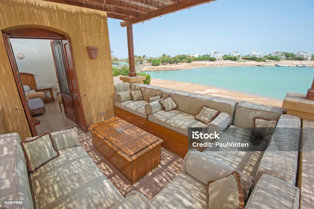 Terrace balcony with chairs in tropical luxury apartment Terrace furniture of a luxury villa in tropical resort with chairs and sea view over lagoon Architectural Column Stock Photo