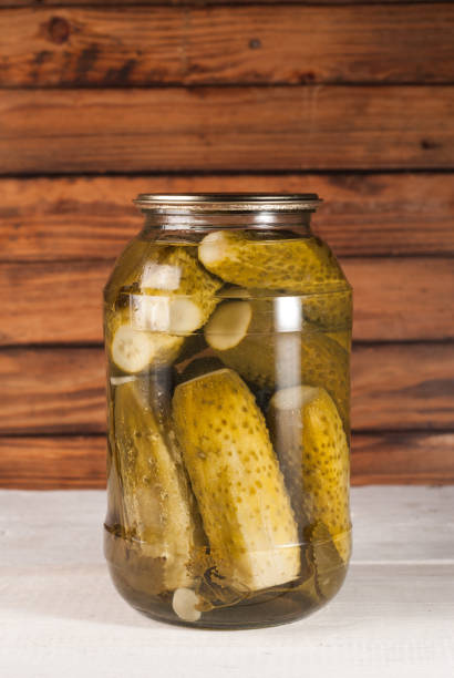 istock Pickled cucumbers on wooden background. Pickled cucumbers in a jar 831821252