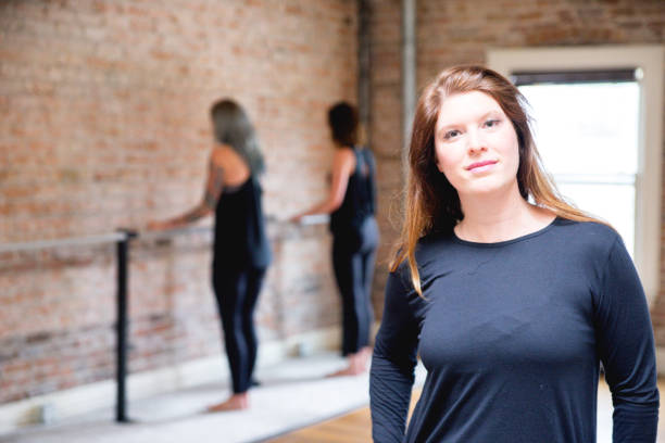 istock Woman Posing in Barre Studio with Others in Background 831822364