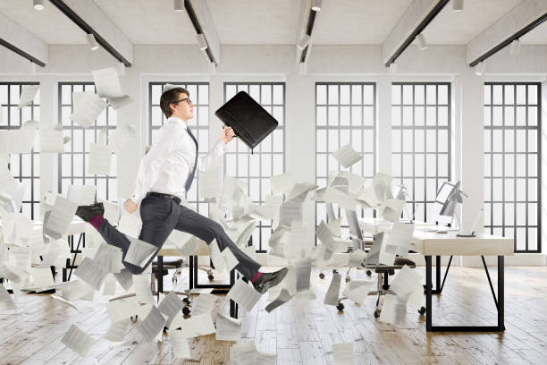istock Businessman jumping in an office, papers 831824926