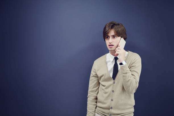 istock young casual man talking on the phone isolated on gray background 831832202
