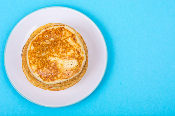 istock Stack of fresh delicious pancakes on white plate on blue backgro 831833502