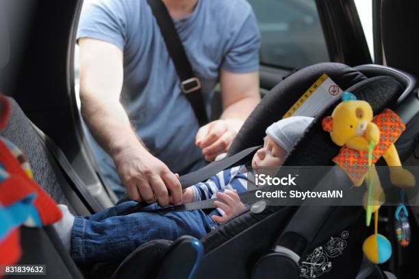 Father Fasten His Little Son In Car Seat Stock Photo - Download Image Now - Baby - Human Age, Chair, Car