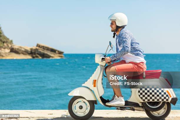 Handsome Man Posing On A Scooter In A Vacation Context Street Fashion And Style Stock Photo - Download Image Now