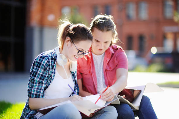 istock Young happy students with books and notes in University campus 831840516