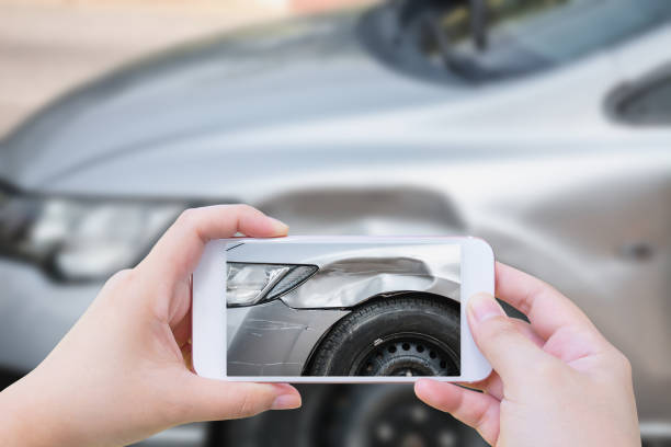 mujer con móvil smartphone tomar accidente de accidente de coche foto - accidente de automóvil fotos fotografías e imágenes de stock
