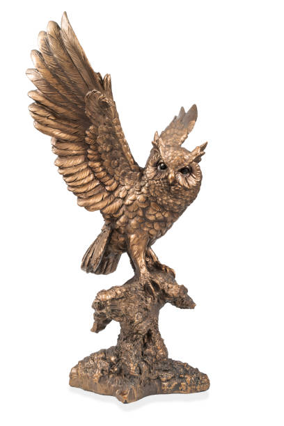 Figurine of a flying owl A bronze statuette of a flying owl with flapping wings isolated on white background bronze statue stock pictures, royalty-free photos & images