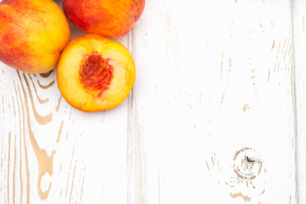 istock a lot of fresh peaches on a white table. Top view. 831860894