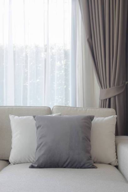 istock Pillows setting on couch with dark gray curtain in background 831867932