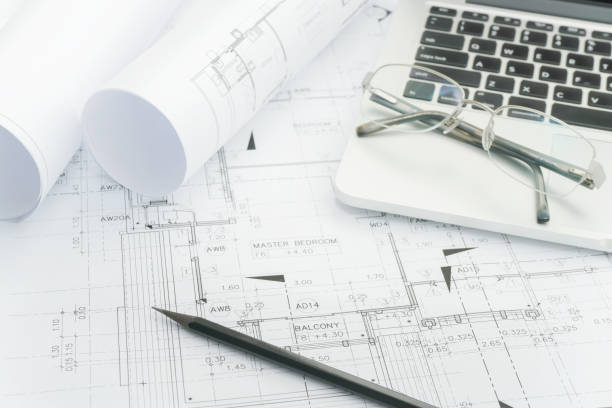 istock black pencil and computer laptop on architectural drawing paper for construction 831868244