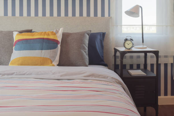 istock Colorful style bedding bedroom interior and clock on bedside table 831869250