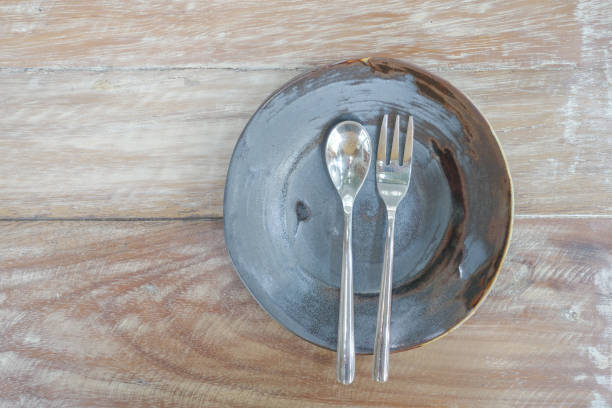 istock Plates with spoon and fork on wooden table 831869306