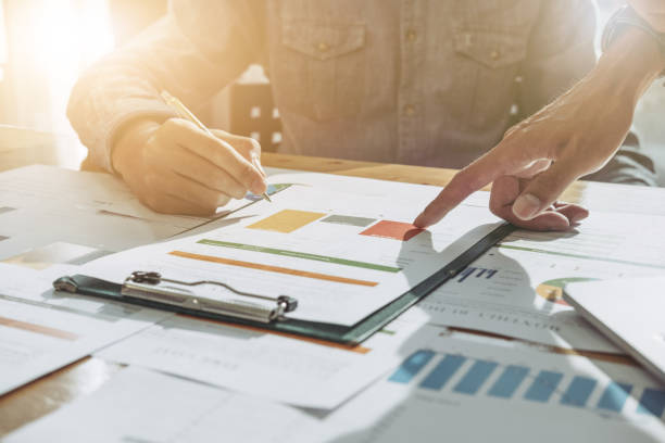 istock Businessman and partner discussing report on chart  in office 831881400