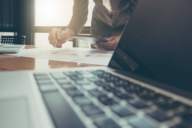 istock Businessman using tablet and laptop computer to work with financial data 831883646